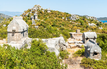 Mountainous landscape with scattered Lycian sarcophagus tombs near Kalekoy village in Kekova region of Antalya province of Turkey.