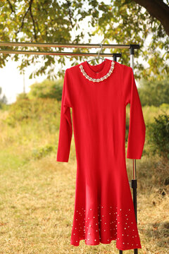 A Stylish Red Dress On A Hanger. Beauty And Fashion.