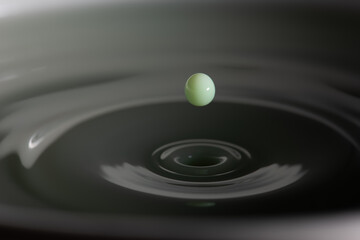 Green liquid droplet renouncing bath of liquid
