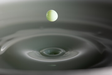 Green liquid droplet renouncing bath of liquid