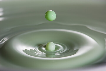 Green liquid droplet renouncing bath of liquid