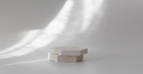 Empty gypsum stones platform podium on white light and shadow interior horizontal long background....