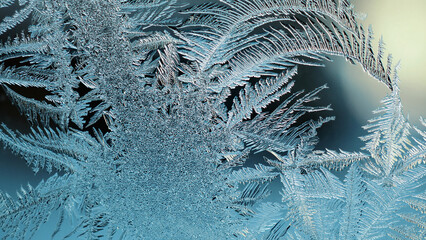 Abstract Christmas wallpaper. Ice crystals on frozen window glass. Frost drawing. Dark blue tinted background similar to moonlit winter night. Frostwork and frosting pattern. Cold and crystal. Macro
