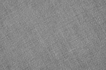 Fototapeta na wymiar Gray woven surface close up. Linen textile texture. Fabric handicraft background. Textured braided grey backdrop. Len black and white wallpaper. Macro