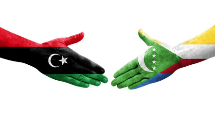 Handshake between Comoros and Libya flags painted on hands, isolated transparent image.