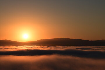 Naklejka premium sunset over the clouds