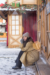 Happy pretty girl during Christmas holidays in a festive town at a Christmas market