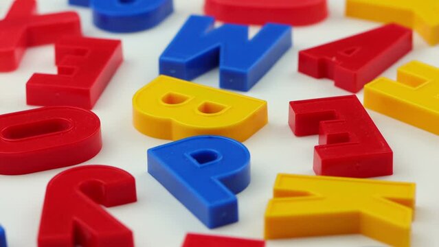 Colorful letters rotate on a white background.