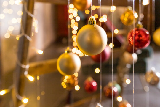 New Year Tree Art Installation Made With String Lights And Christmas Balls Hanging On Threads On Blurred Background.christmas Ornaments Hanging On The Rope