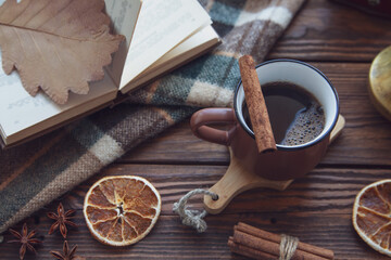 Autumn mood, autumn atmosphere. A cup of hot coffee, a checkered plaid, cinnamon sticks, star...