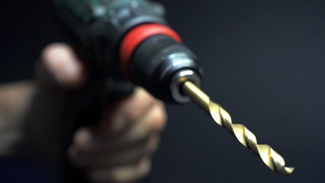 Slow motion close up of drill bit drilling into wood. Joinery and construction work close up. Wood chippings fly off a metal drill. Handyman bores holes into a wooden board. 