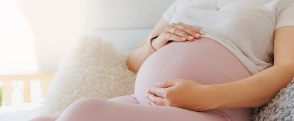 Banner pregnant woman touches belly tenderly. Laying in bed in morning. Concept baby love