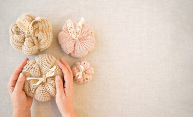 Hobby background with handmade knit pumpkins. DIY, craft decoration for fall and winter holidays. Flat lay, top view