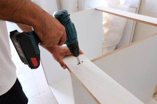 Close Up. The carpenter works with wood on his workspace.Carpentry uses a cordless drill to drill wood. Capenter workshop
