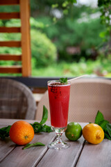 alcoholic cocktail with candy and mint leaves of sake, raspberry, passion fruit, violet liqueur and pineapple juice