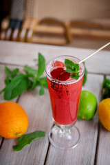 alcoholic cocktail with candy and mint leaves of sake, raspberry, passion fruit, violet liqueur and pineapple juice