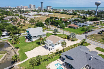 Fototapeta na wymiar Aerial looking north over Daytona Beach Shores residential riverfront neighborhood in the foreground with Daytona Beach high rise condos and hotels in the background.
