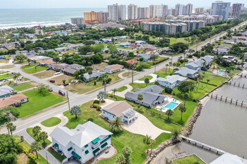 Aerial of Daytona Beach Shores residential neighborhood  in the foreground with high rise condos and hotels in the background. - obrazy, fototapety, plakaty