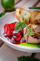 Chicken liver pate with croutons and strawberries in sweet sauce