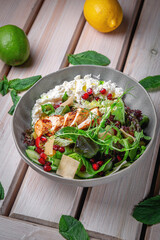 salad with chicken and homemade cheese, garnished with greens, arugula and pomegranate berries