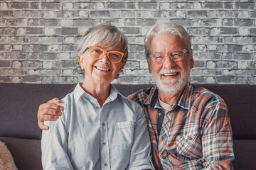 Portrait of couple of mature people wearing glasses and looking at the camera together. Close up of two seniors sitting on the sofa having fun and enjoying. - Powered by Adobe