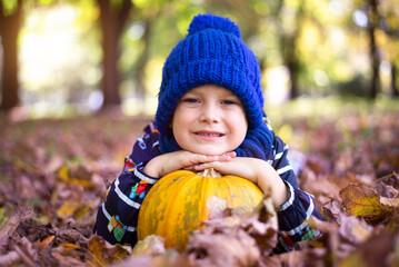 Happy little child baby boy laughing and playing in the autumn