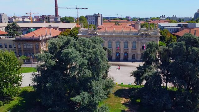 Aerial view of the cityscape and the main buildings of the Polytechnic University Interfacolt&agrave; PoliMi. Campus and library. Green lawns and trees. Students. Architecture. Milan Italy 03.2023
