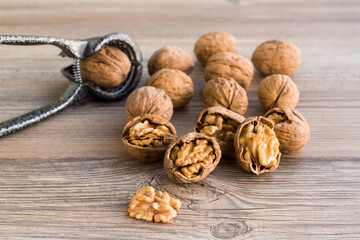 Newly harvested walnuts, designed on wooden table with a walnut cracker,conceptual image