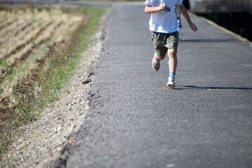 田舎道を走る少年