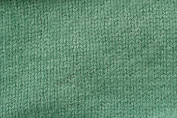 green wool knitted texture as a winter clothes background