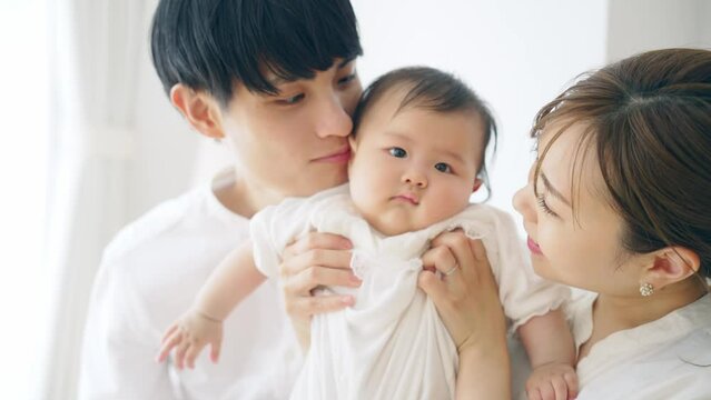 赤ちゃんを抱っこするカップル　子育てイメージ