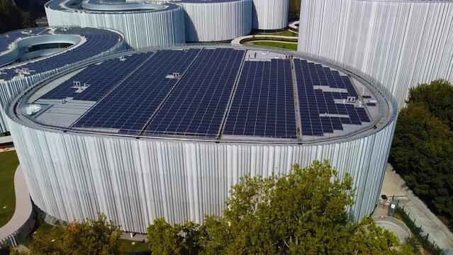 Aerial view of solar panels on the roof. The new campus of the SDA Bocconi School of Management is a modern building with classrooms. Autumn trees. Ecological energy. Milan Italy 11.2022