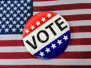 Close up of a vote campaign button on an American flag