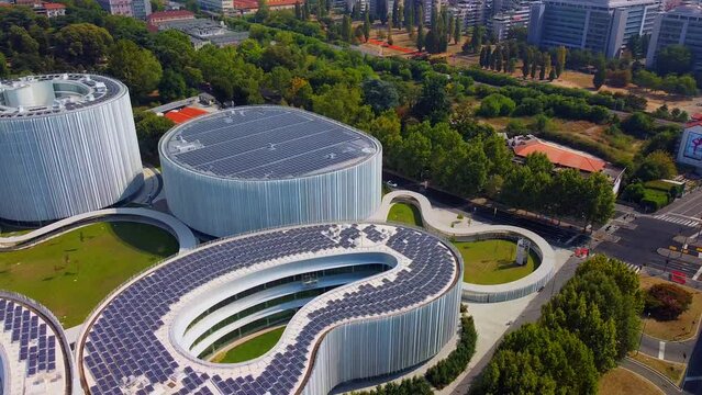 Aerial view of solar panels on the roof. The new campus of the SDA Bocconi School of Management is a modern building with classrooms. Autumn trees. Ecological energy. Milan Italy 11.2022