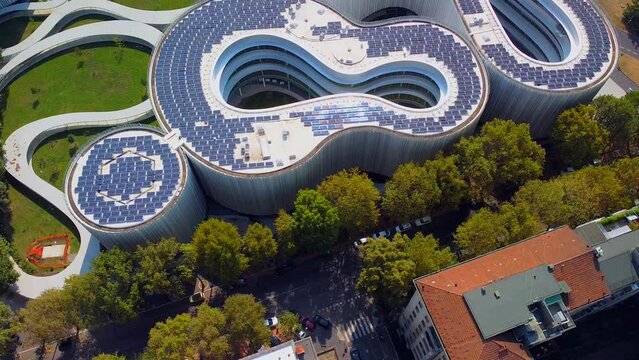 Aerial view of solar panels on the roof. The new campus of the SDA Bocconi School of Management is a modern building with classrooms. Autumn trees. Ecological energy. Milan Italy 11.2022