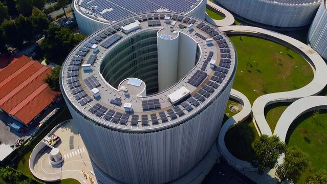 Aerial view of solar panels on the roof. The new campus of the SDA Bocconi School of Management is a modern building with classrooms. Autumn trees. Ecological energy. Milan Italy 11.2022