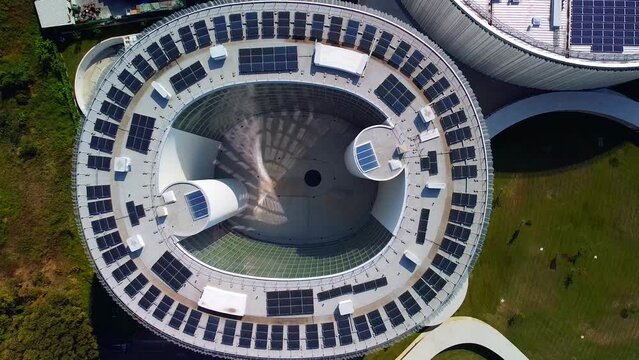 Aerial view of solar panels on the roof. The new campus of the SDA Bocconi School of Management is a modern building with classrooms. Autumn trees. Ecological energy. Milan Italy 11.2022