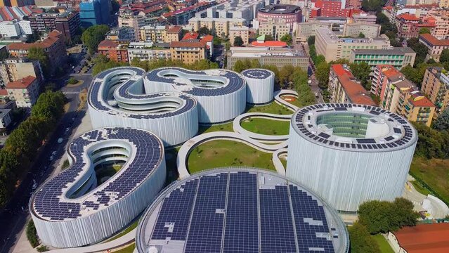 Aerial view of solar panels on the roof. The new campus of the SDA Bocconi School of Management is a modern building with classrooms. Autumn trees. Ecological energy. Milan Italy 11.2022