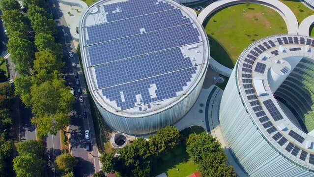 Aerial view of solar panels on the roof. The new campus of the SDA Bocconi School of Management is a modern building with classrooms. Autumn trees. Ecological energy. Milan Italy 11.2022
