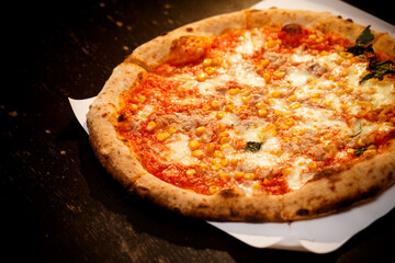 pizza baked in the oven. Pizza with corn on a black background. photo for pizzeria menu.