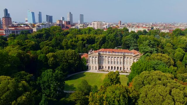 Aerial view of summer trees in Giardini Indro Montanelli park and skyline with new skyscrapers. View of modern business offices. Business. Tourism. Ecology. Clouds over the city. Green Planet. Milan. 
