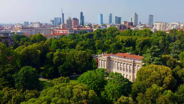 Aerial view of summer trees in Giardini Indro Montanelli park and skyline with new skyscrapers. View of modern business offices. Business. Tourism. Ecology. Clouds over the city. Green Planet. Milan. 