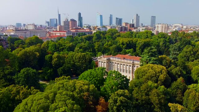 Aerial view of summer trees in Giardini Indro Montanelli park and skyline with new skyscrapers. View of modern business offices. Business. Tourism. Ecology. Clouds over the city. Green Planet. Milan. 