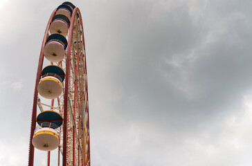 Attraction ferris wheel on the background of a stormy sky.