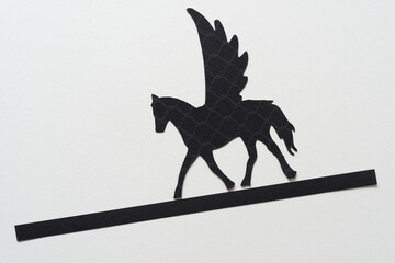 glyph or dingbat of pegasus (winged horse) cutout and black paper stripe sloping downwards - obrazy, fototapety, plakaty