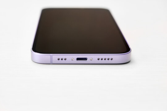 Moscow, Russia, 10,09.2022 - Bottom part of purple iphone 12 smartphone iwith proprietary lightning charger connector, speaker and microphone. Iphone charger connector. Apple gadgets.