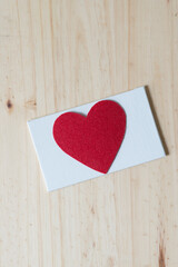 red heart on blank canvas-board isolated on a wooden surface