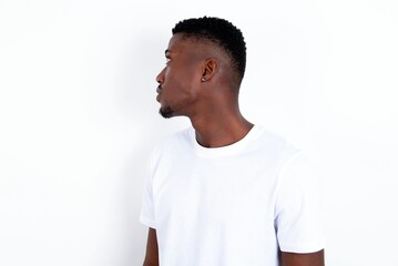 Side view of young happy smiling young handsome man wearing white T-shirt over white background 