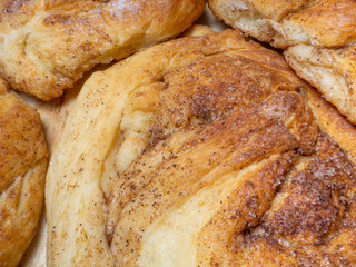 Wicker bun with cinnamon and sugar. Bread product of an unusual shape. Homemade baking. Buns with a ruddy crust.
