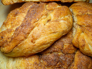 Wicker bun with cinnamon and sugar. Bread product of an unusual shape. Homemade baking. Buns with a ruddy crust.